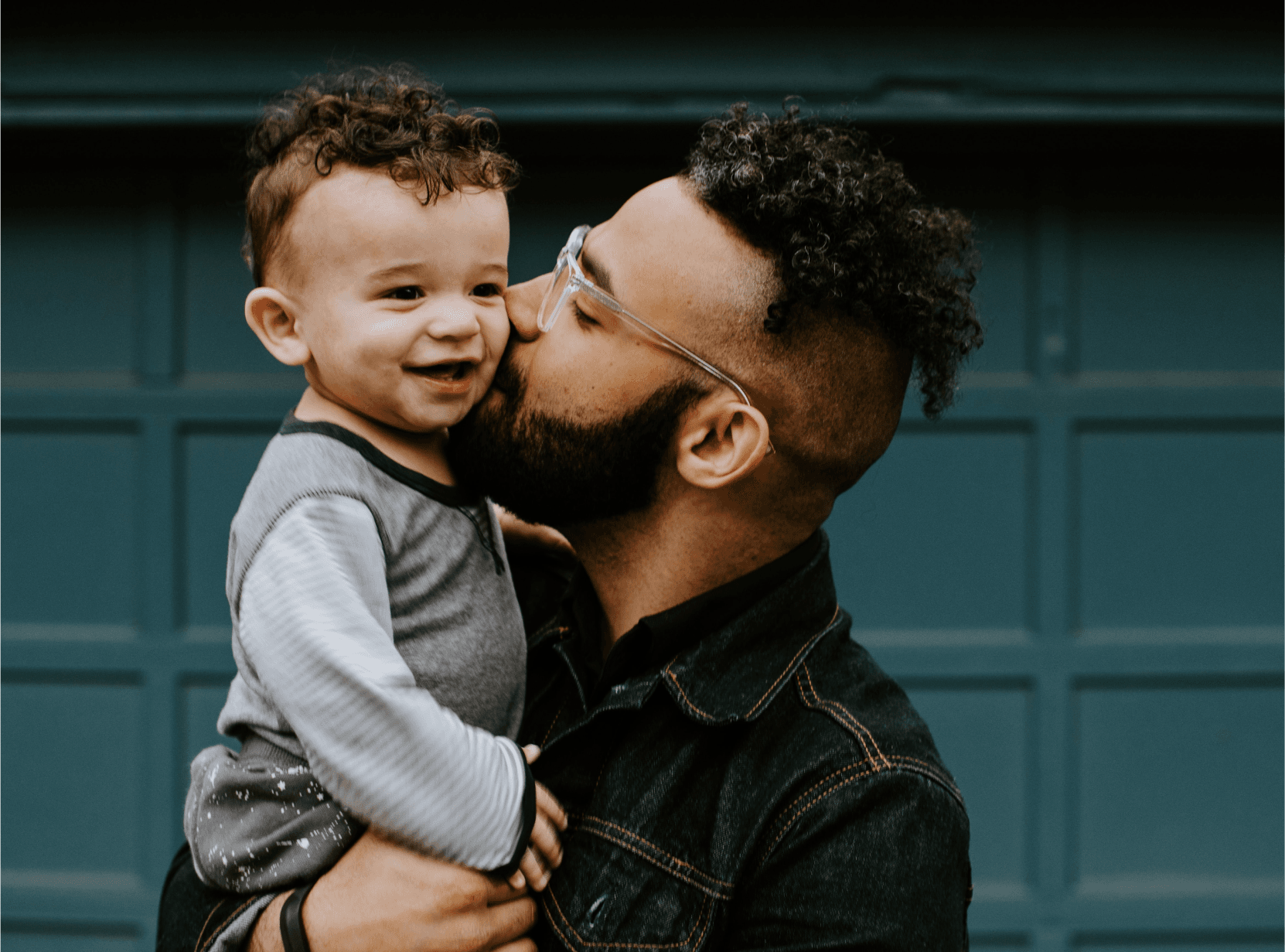 Father holding son and kissing him on the cheek